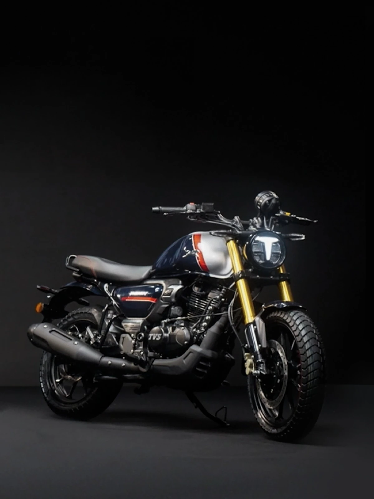 TVS Ronin 2025 मॉडल, काले बैकग्राउंड में खड़ी हुई, प्रीमियम डिजाइन और गोल्डन फ्रंट सस्पेंशन के साथ।