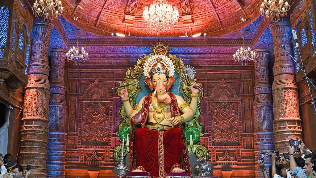 "Lalbaugcha Raja की भव्य प्रतिमा, गिरगांव में भव्य पंडाल के भीतर, रोशनी और सजावट से सजी हुई।"